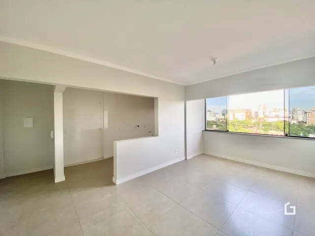 Vista interna de um ambiente com paredes brancas e piso claro.