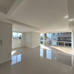 Sala ampla com piso claro e muita luz natural entrando pelas janelas.