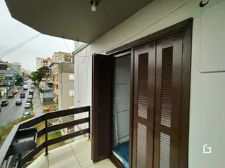Fachada de um imóvel em Lajeado, Brasil, com portas de madeira e grade de segurança.