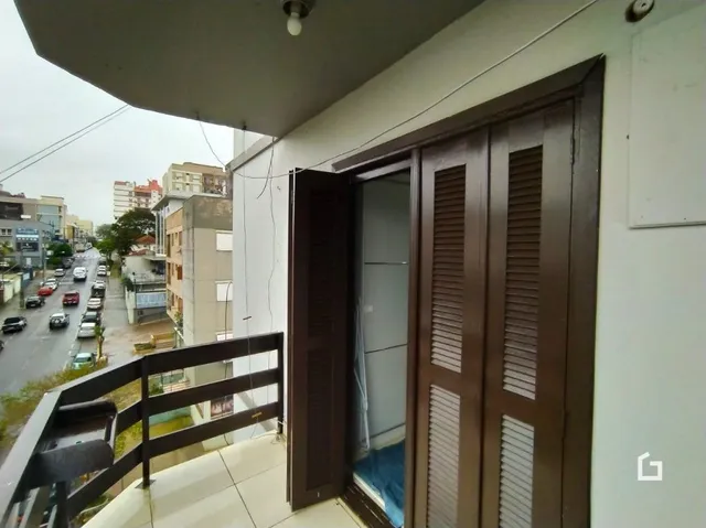 Fachada de um imóvel em Lajeado, Brasil, com portas de madeira e grade de segurança.