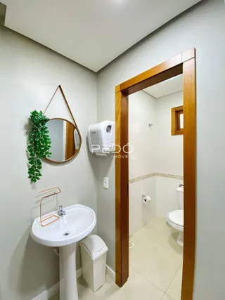 Vista interna de um banheiro com pia e vaso sanitário.