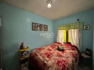 Quarto com cama e janela em uma residência.