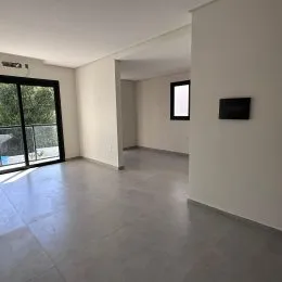 Ambiente interno com piso de concreto e paredes brancas.