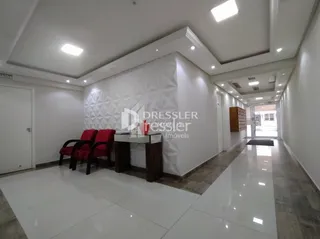 Hall de entrada com piso branco e paredes claras.