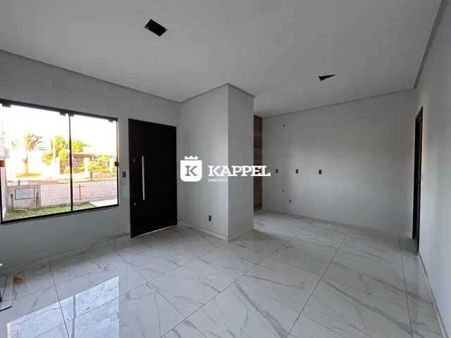 Foto de uma sala ampla com piso de porcelanato claro e grande janela lateral.