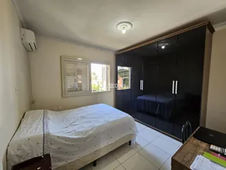 Quarto com cama e armários embutidos escuros.