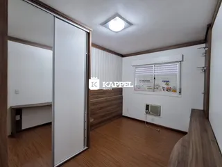 Ambiente interno com piso de madeira e janelas com ar-condicionado.
