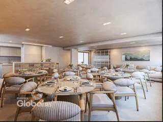Uma sala de jantar ampla com mesas redondas montadas para um evento.