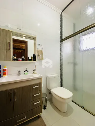 Foto de um banheiro com revestimento branco e armários de madeira.