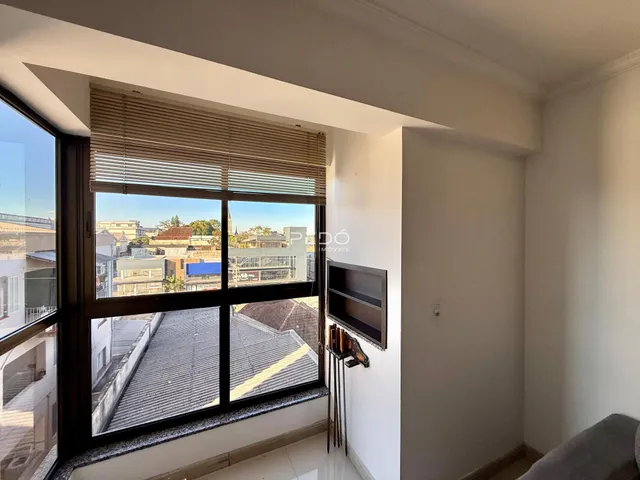 Sala com grande janela oferecendo vista da paisagem urbana.