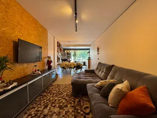 Sala de estar com sofá e televisão em um ambiente com parede de textura.