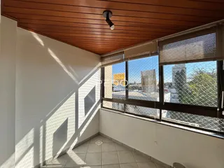 Interior de um cômodo com teto de madeira e janela com vista para o exterior.