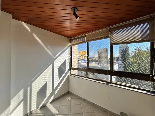 Interior de um cômodo com teto de madeira e janela com vista para o exterior.