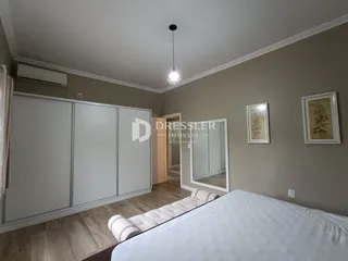 Quarto com armários embutidos e piso de madeira clara.
