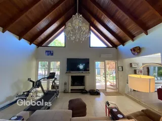 Sala de estar ampla com teto abobadado de madeira e lareira.