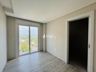 Sala de estar com porta de vidro abrindo para a varanda.