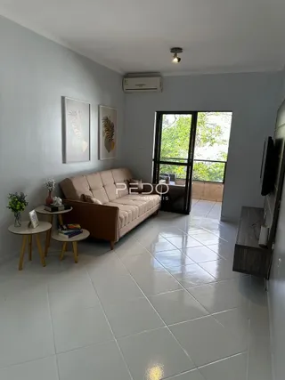 Sala de estar com sofá e piso de cerâmica clara.