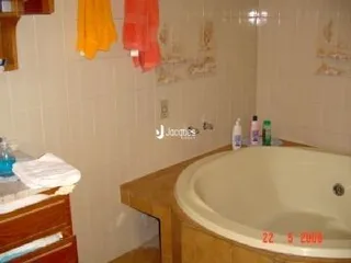 Foto de um banheiro interno com banheira e paredes claras.