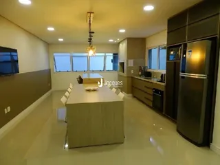 Uma sala de estar longa com janelas e armários.