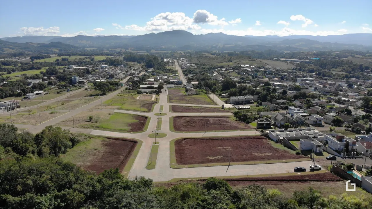 Vista aérea de um terreno aberto com áreas de plantio e vegetação.