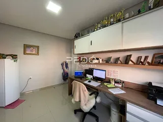 Ambiente interno de uma cozinha com armários brancos e prateleiras de madeira.