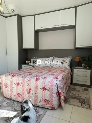 Quarto com cama e armários brancos na residência.