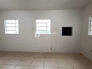Foto de uma sala interna com paredes brancas e piso de cerâmica.