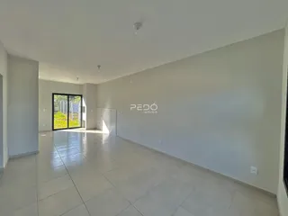 Interior de um espaço amplo com piso de cerâmica claro.