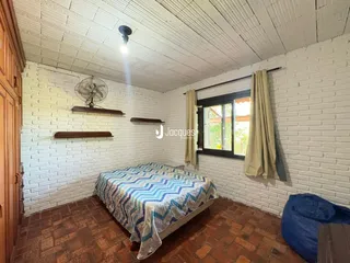 Quarto com paredes de tijolo aparente e piso de terracota.