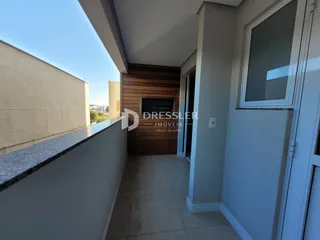Vista de uma varanda com piso de cerâmica e parede de acabamento em madeira.