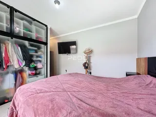 Quarto com cama e armário de vidro.