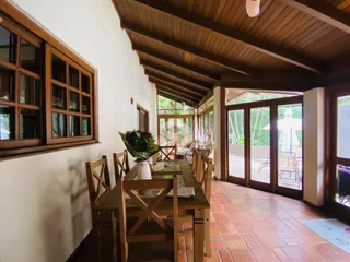 Uma sala de jantar com piso de tijolos vermelhos e teto de madeira.