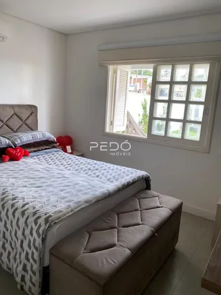 Foto interna de um quarto com cama e janela.