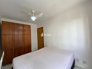 Quarto com armário de madeira e cama de casal.
