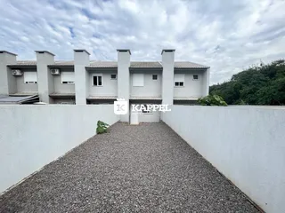 Foto da fachada de um prédio residencial em Lajeado, Brasil, vista por um caminho de cascalho.