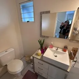 Foto de um banheiro mostrando um vaso sanitário e uma bancada branca.