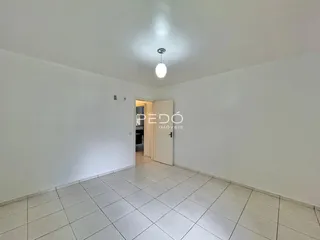 Vista de um corredor interno com piso de cerâmica clara.