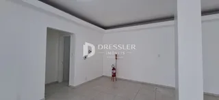 Interior de um corredor com paredes brancas e piso de cerâmica.