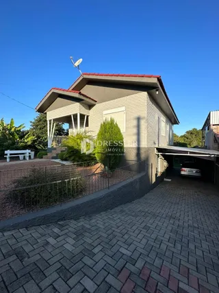 Fachada de uma casa em Lajeado, Brasil, com telhado de telhas e área pavimentada.