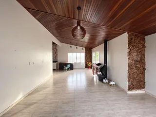 Sala de estar com teto de madeira e piso de cerâmica.
