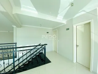 Hall de entrada com escadaria e paredes brancas em um imóvel no Brasil.