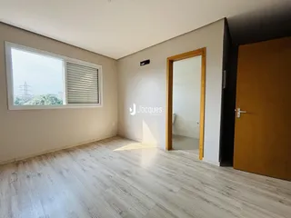 Sala de estar com piso de madeira clara e janela.