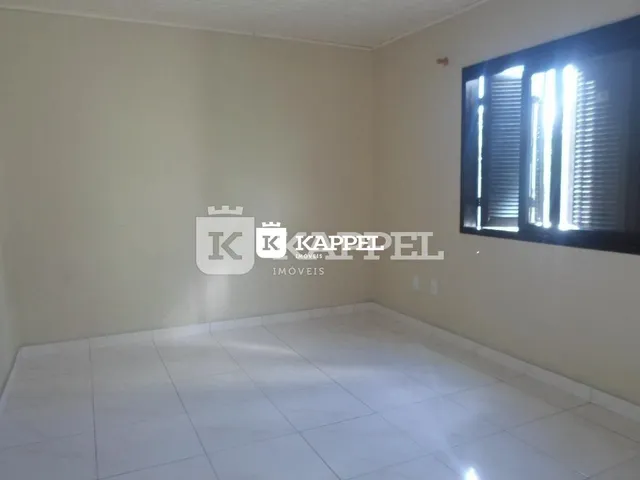 Foto de um cômodo vazio com paredes brancas e piso claro.