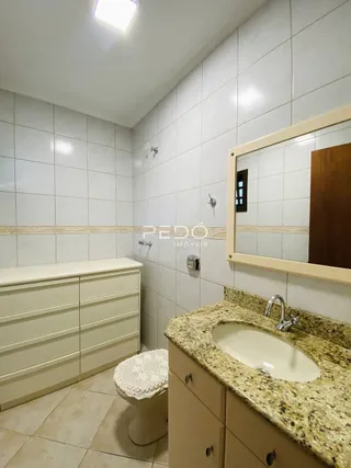 Foto da área de banheiro com revestimento cerâmico branco.
