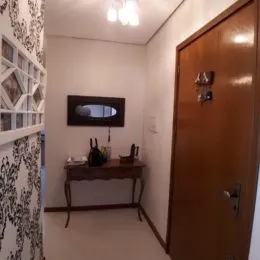 Foto interna de um cômodo com uma escrivaninha de madeira e porta de madeira.