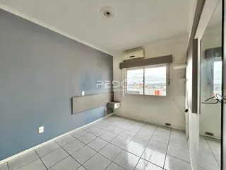 Sala com piso de cerâmica e vista da cidade.