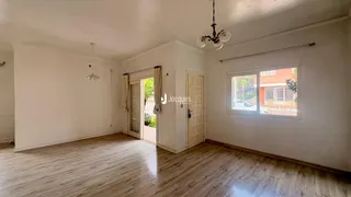 Uma sala de estar com piso de madeira clara e porta de entrada para o exterior.