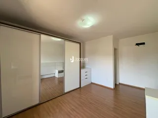 Sala de estar com piso de madeira clara e portas de correr brancas.