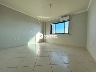 Uma sala ampla com piso de cerâmica clara e janela voltada para o exterior.