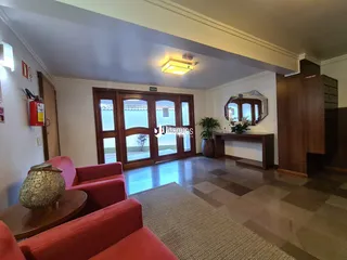 Sala de estar com móveis vermelhos e piso de ladrilhos no imóvel em Lajeado.